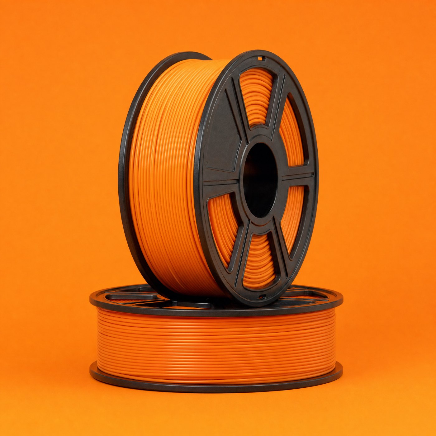 Zwei Spulen mit orangem Filament auf orangem Grund
