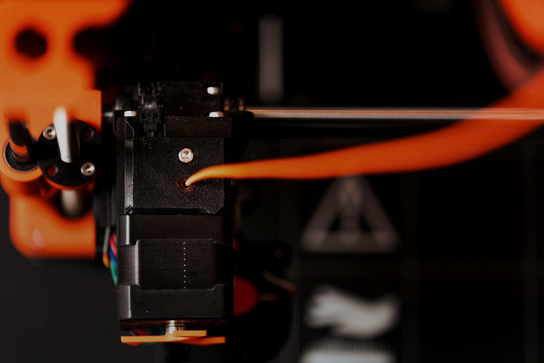 Hotend einer FDM-Anlage mit orangem Filament